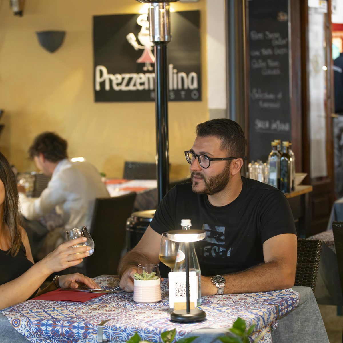 Cena ai tavoli nel vicolo di via Cesare Battisti